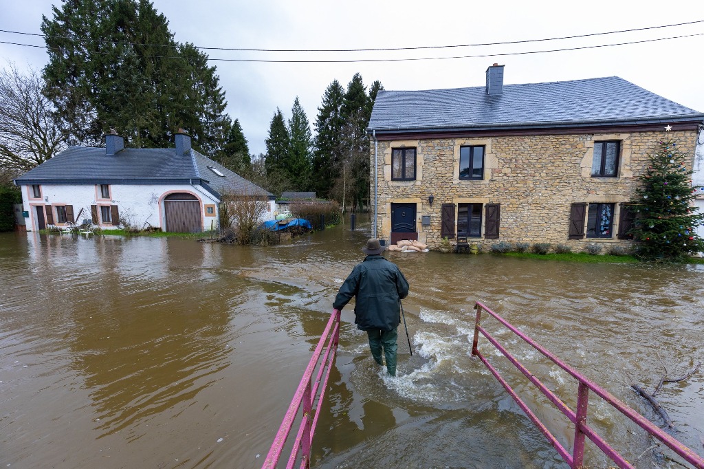 Moyen. Un peatón camina por una calle inundada tras el temporal en esta urbe belga, el 3 de enero de 2024. Foto Afp / julien Warnand 