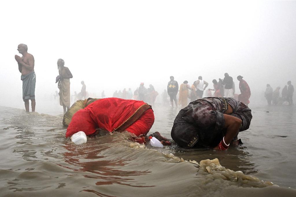 Isla Sagar. Peregrinos toman un baño sagrado en medio de una densa niebla en la confluencia del río Ganges y la Bahía de Bengala durante el festival hindú de Makar Sankranti, en esta urbe india. El evento se realiza en honor al dios del sol, Suria, y a la madre tierra, Saraswati Maa. Foto Afp / Dibyangshu Sarkar