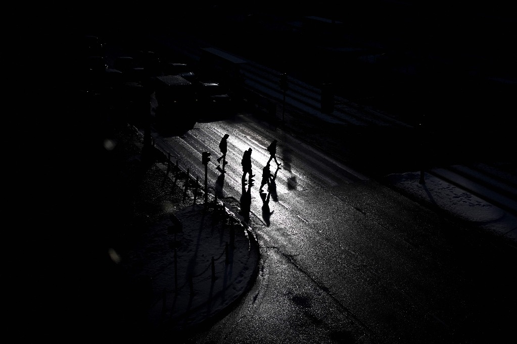 Varosvia. Peatones cruzan una calle oscura mientras brilla el sol en la capital polaca. Foto Afp / Sergei Gapon