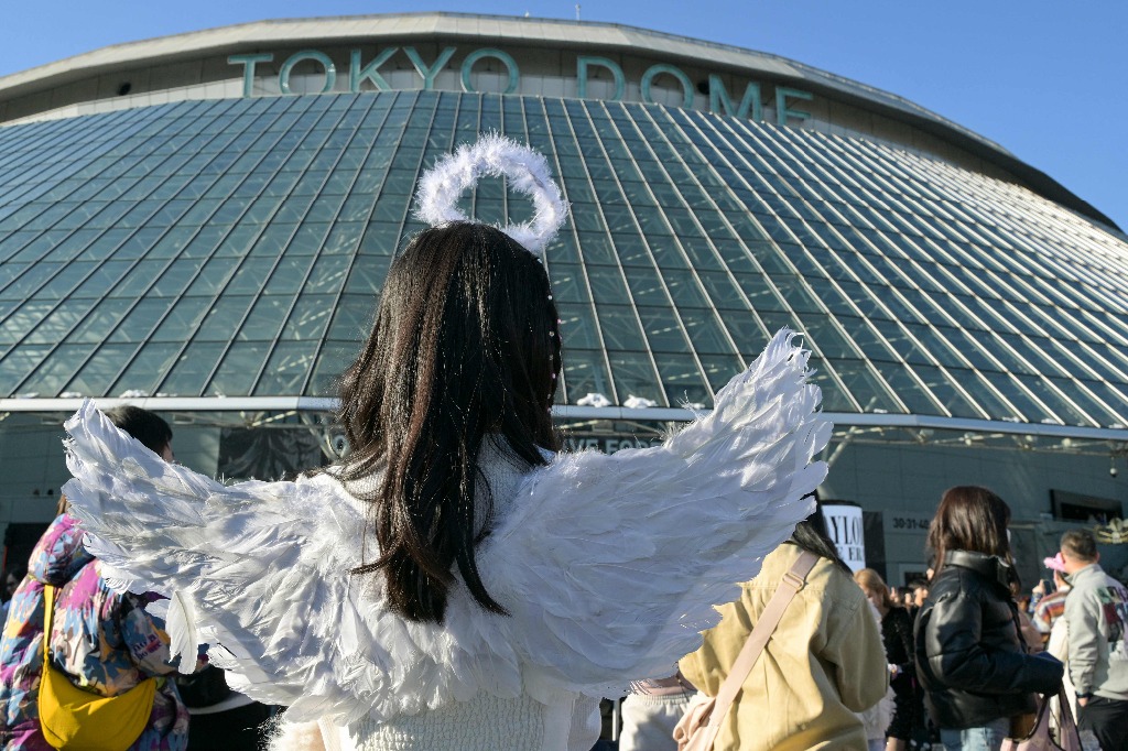 Tokio. Una fan de la cantante estadunidense Taylor Swift, con un disfraz de ángel, es vista frente al Tokyo Dome, unas horas antes de la primera etapa de su gira Asia-Pacífico "Eras Tour", en la capital japonesa. Foto Afp / Richard A. Brooks