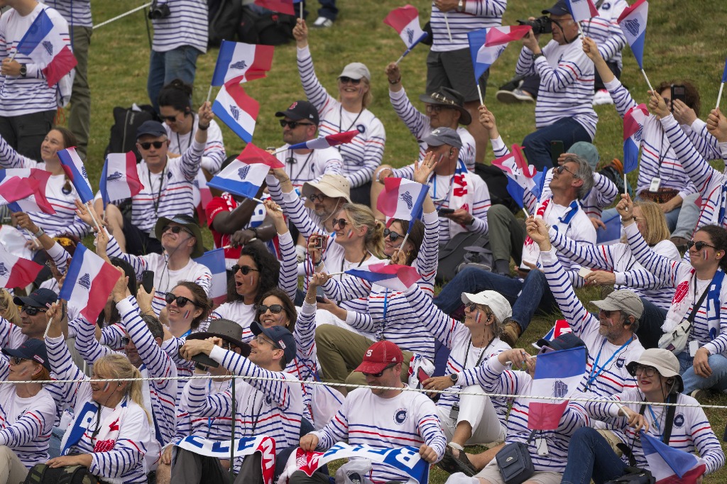 Los espectadores ondean banderas francesas. Foto Ap / Petros Giannakouris