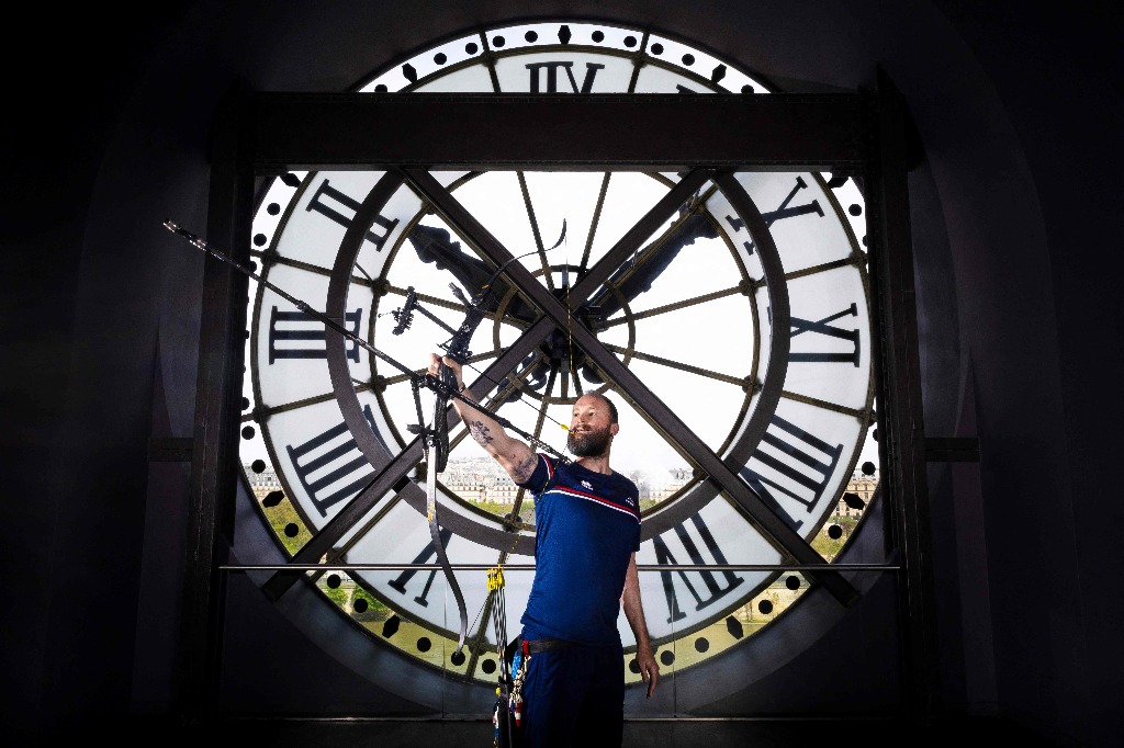 El arquero paralímpico Guillaume Toucoullet posa frente al reloj del Museo Orsay en la capital francesa, el 4 de abril de 2024. Construido como estación de tren y terminado en 1900, se transformó e inauguró como museo en 1986 y se convirtió en la colección de pinturas impresionistas más grande del mundo. Foto Afp / Franck Fife