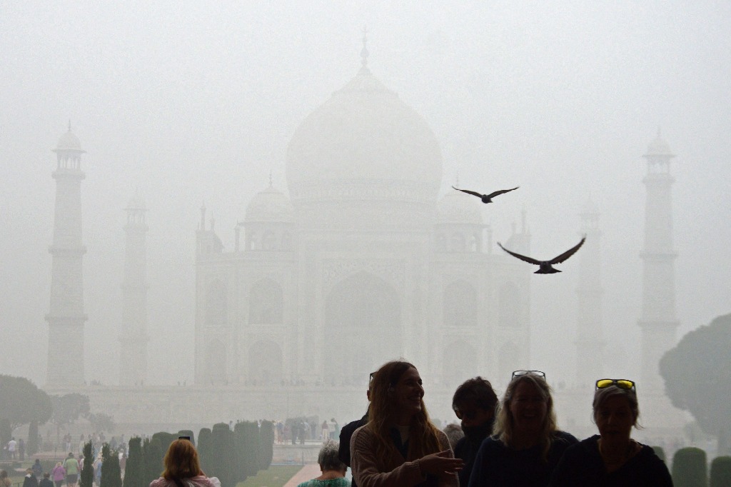 Agra. Turistas visitan el Taj Mahal en una fría mañana con smog en esta ciudad india. Foto Afp / Pawan Sharma