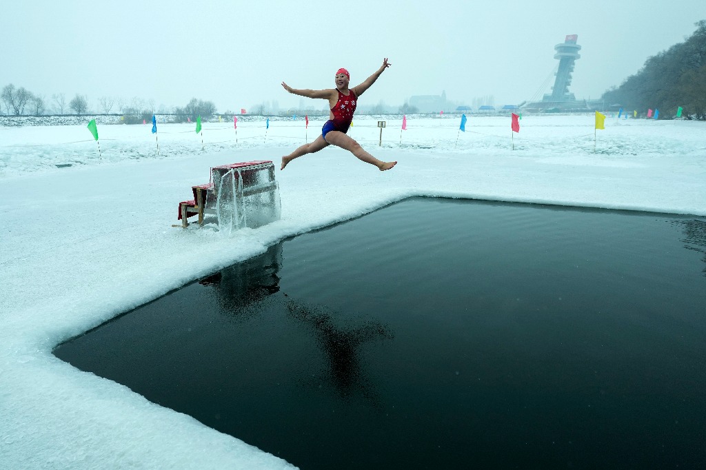 China. Yu Xiaofeng salta a una piscina tallada en hielo en el río congelado Songhua en Harbin, en la provincia de Heilongjiang, al noreste de este país. Foto Ap / Andy Wong