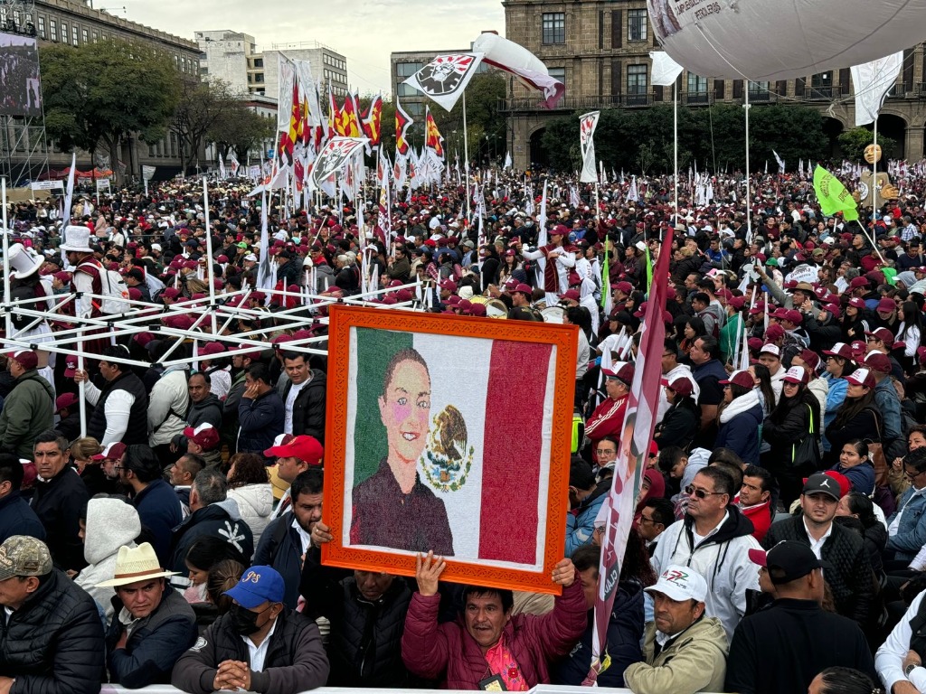 Una persona alza una pintura de la Presidenta Claudia Sheinbaum, durante el “Informe 100 días de Gobierno”, de la Presidenta de México, Claudia Sheinbaum, frente a Palacio Nacional. Foto Luis Castillo