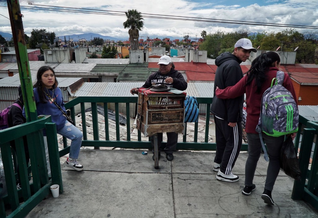 Ciudad de México. Un organillero toca en un puente mientras peatones disfrutan de la vista del volcán Iztaccíhuatl desde la alcaldía Iztapalapa. Foto  Jair Cabrera Torres