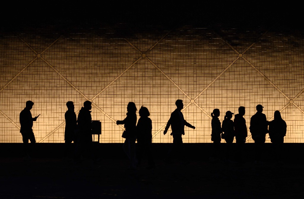 Hong Kong. Siluetas de personas se contemplan junto a la cúpula del Museo Espacial de esta ciudad. Foto Afp / Mladen Antonov