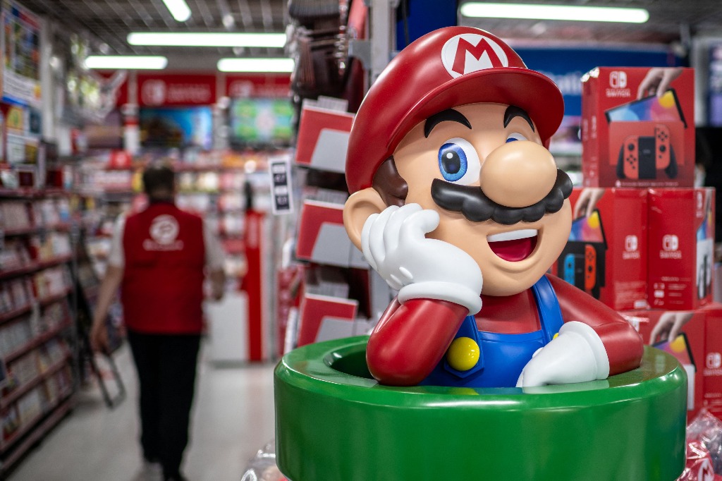 Tokio. Una figura del personaje Mario Bros se observa en un pasillo de la sección de videojuegos para productos de Nintendo Switch, por donde camina un empleado de una tienda en la capital japonesa. Foto Afp / Philip Fong