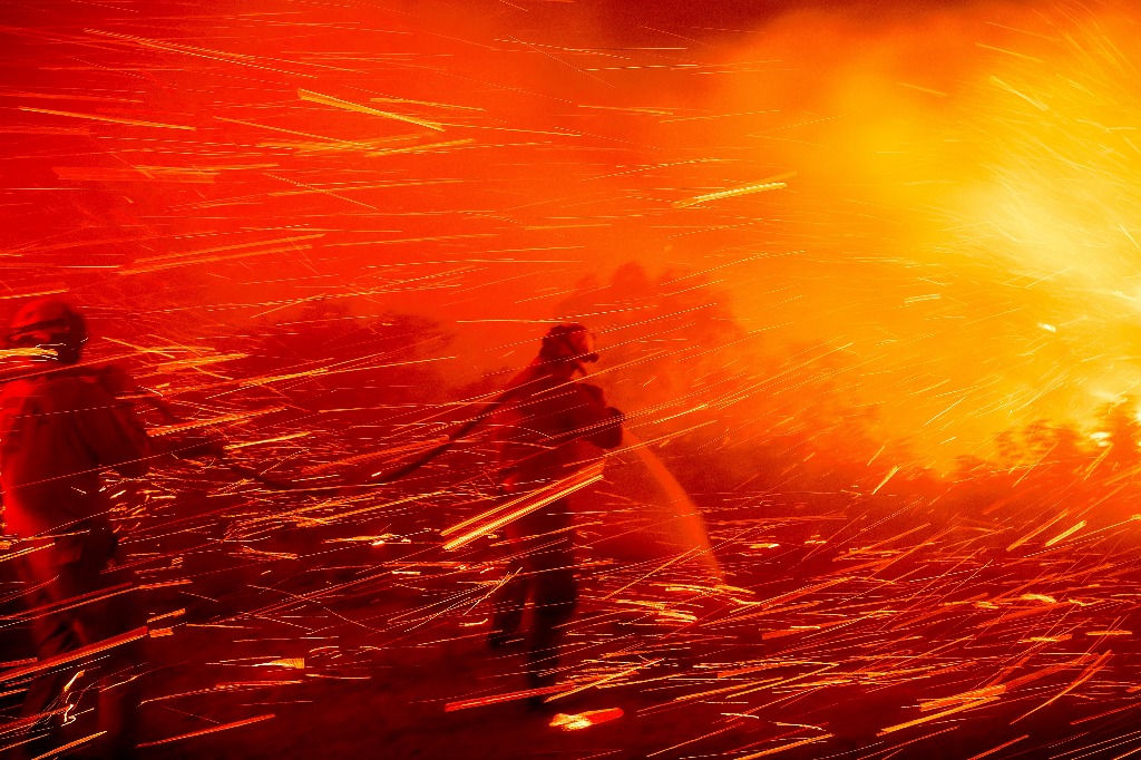 San Diego. El bombero Joshua Cari rocía agua mientras lucha contra el incendio ‘Lilac’ cerca de la comunidad de Bonsall de este condado de California. Foto Ap / Noah Berger